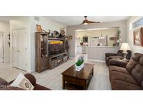 Inviting living room features a decorative entertainment center, hardwood floors and natural lighting at 15790 W Arrowhead Dr, Surprise, AZ 85374
