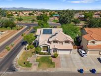 Two-story home featuring solar panels, a two-car garage, and a well-maintained front lawn at 2024 N 125Th Ave, Avondale, AZ 85392