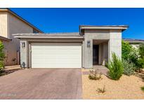 Modern home featuring a two-car garage, desert landscaping, and a neutral color palette under a clear blue sky at 32611 N 20Th Dr, Phoenix, AZ 85085