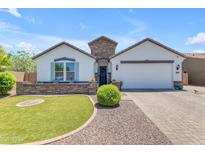 Charming single-story home featuring a well-manicured lawn, stone accents, and a welcoming two-car garage at 35701 N Bandolier Dr, San Tan Valley, AZ 85144