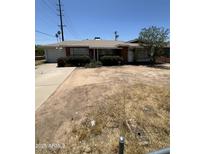 Single level brick home with attached garage and dry landscaping in need of renovation at 3701 W Keim Dr, Phoenix, AZ 85019