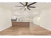 Spacious living room boasts an open floor plan, wood floors, and a modern ceiling fan at 4701 N 63Rd Dr, Phoenix, AZ 85033