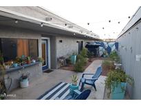 Cozy backyard patio featuring string lights, garden, and blue accent furniture at 8848 N New World Dr, Glendale, AZ 85302