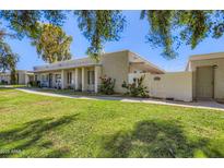 Inviting single-story home featuring desert landscaping, shade trees, and a private gated entrance in a well-maintained community at 8848 N New World Dr, Glendale, AZ 85302