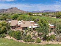 Expansive aerial view of a Southwestern home featuring a tile roof, desert landscaping, and a golf course backdrop at 1637 N Quartz Valley Rd, Scottsdale, AZ 85266