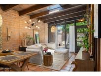 Bright living room features brick walls, terracotta tile flooring, and contemporary lighting fixtures at 3032 N 32Nd St # 61, Phoenix, AZ 85018
