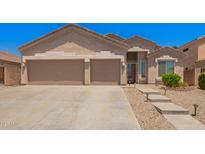 A home with a spacious three car garage and desert landscaping in front at 9142 W Pontiac Dr, Peoria, AZ 85382