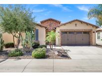 Charming home featuring desert landscaping, a two-car garage, and a brick-accented facade at 119 E Camellia Way, San Tan Valley, AZ 85140