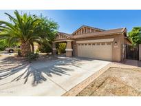 Charming home features a spacious driveway, mature landscaping, and a two-car garage at 1688 W Corriente Dr, San Tan Valley, AZ 85144