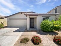 Charming single-story home featuring a two-car garage, covered entry, and meticulously landscaped front yard at 1953 W Stage Driver St, Apache Junction, AZ 85120