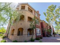 Three-story exterior view of condo showing balconies and arched ground floor terraces with desert landscaping at 5401 E Van Buren St # 1088, Phoenix, AZ 85008