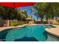 Backyard pool featuring a baja shelf, a tanning ledge, ample seating, and privacy landscaping at 5534 W Riviera Dr, Glendale, AZ 85304