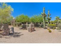 Expansive front yard featuring native desert landscaping and a gated entrance to the property at 8306 E Buckskin Trl, Scottsdale, AZ 85255