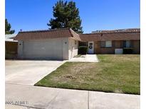 Charming single-story home featuring a well-maintained front lawn, attached garage, and welcoming entrance with desert landscaping at 10727 W Kelso Dr, Sun City, AZ 85351