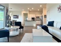 Bright living room with an open layout, white furniture, and modern finishes, adjacent to kitchen at 20952 E Via Del Sol --, Queen Creek, AZ 85142