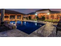 Inviting backyard pool with covered patio and lush landscaping, perfect for relaxation and outdoor entertaining at 3718 N Briere Ct, Buckeye, AZ 85396
