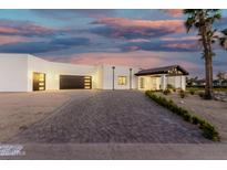 Stunning single-story home with a modern design, three-car garage, and porte cochere at 6401 E Larkspur Dr, Scottsdale, AZ 85254