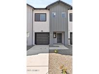 Stylish townhouse featuring a modern design with a gray and white color scheme and attached garage at 7448 S 75Th Ln, Laveen, AZ 85339