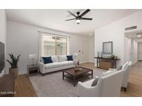 Bright living room featuring a neutral color palette, contemporary furnishings, and a ceiling fan at 934 E Wahalla Ln, Phoenix, AZ 85024