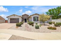 Inviting single-story home with a three-car garage, desert landscaping, and stone walkway at 23090 S 201St St, Queen Creek, AZ 85142