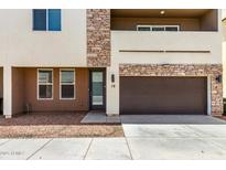 Modern townhome with a brown garage door and stone accents on the exterior facade at 2000 N 36Th St # 19, Phoenix, AZ 85008