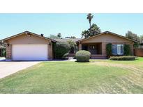 Charming single-story home featuring a well-manicured lawn and a classic brick exterior at 3033 W Tierra Buena Ln, Phoenix, AZ 85053