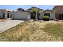 Charming home featuring a two-car garage, and mature landscaping with palm trees at 317 E Nunneley Rd, Gilbert, AZ 85296