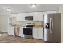 Well-lit kitchen featuring stainless steel appliances, bright white cabinetry, and laminate countertops at 320 E Mckellips Rd # 245, Mesa, AZ 85201