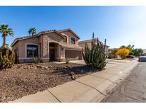 Charming single-Gathering home featuring stone accents, desert landscaping, and an attached two-car garage at 3619 N 104Th Dr, Avondale, AZ 85392