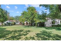 Expansive front yard of Spanish-style home featuring a lush lawn and mature trees, creating a serene and inviting atmosphere at 5225 N 23Rd St, Phoenix, AZ 85016