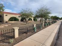 Charming home featuring a brick facade, arched entryways, desert landscaping, and a decorative wrought iron fence at 5801 N 73Rd Ave, Glendale, AZ 85303