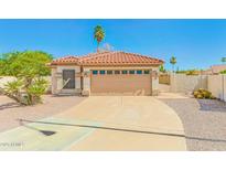 Charming single-story home with a tile roof, well-maintained desert landscaping, and a two-car garage at 1048 N Arroya --, Mesa, AZ 85205