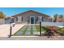 Charming single-story home with a blue front door, desert landscaping and gray exterior paint at 11450 E Elton Ave, Mesa, AZ 85208