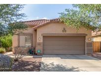 Single-story home with a tile roof, neutral stucco exterior, and a two-car garage at 12910 W Glenrosa Dr, Litchfield Park, AZ 85340