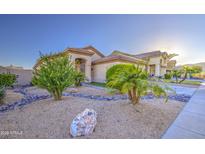 Charming single-story home featuring desert landscaping with decorative rocks and mature palm trees at 1409 E Goldenrod St, Phoenix, AZ 85048