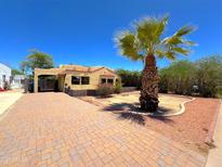 Charming home with a brick driveway and beautiful desert landscaping, including a mature palm tree at 1629 N 17Th Ave, Phoenix, AZ 85007
