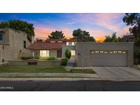 Charming home with a red tile roof, well-maintained lawn, and attached two-car garage at 190 E Tremaine Ave, Gilbert, AZ 85234