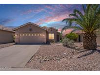 Charming single-story home with desert landscaping, two-car garage and palm tree at 22993 W Micah Way, Buckeye, AZ 85326