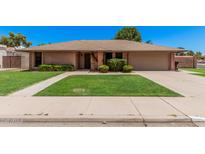 Charming brick home featuring a lush front yard and inviting curb appeal at 2956 E Concho Ave, Mesa, AZ 85204