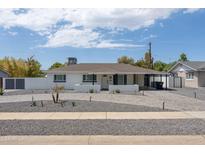 Charming single-story home featuring a well-manicured front yard, stylish gray brick driveway, and freshly painted white exterior at 3814 N 36Th St, Phoenix, AZ 85018