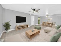 Open-concept living room and dining area featuring hardwood floors, modern furniture, and ceiling fans at 3825 E Camelback Rd # 182, Phoenix, AZ 85018
