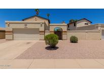 Home exterior featuring a beige facade, front gate, and palm trees at 4644 W Havasupai Dr, Glendale, AZ 85308