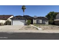 Charming single-story home featuring a two-car garage and a low maintenance front yard landscape at 6407 W Madras Ln, Glendale, AZ 85306