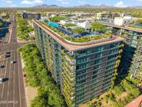 Stunning aerial view of modern building with rooftop pool, gardens, and city skyline in the background at 7180 E Kierland Blvd # 507, Scottsdale, AZ 85254