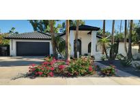 Charming one-story home featuring white brick, dark tile roof, and beautiful Bougainvillea landscaping at 7724 E Charter Oak Rd, Scottsdale, AZ 85260