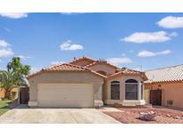 Charming single-story home with a red-tiled roof, neutral stucco and a well-maintained front yard at 12770 W Alvarado Rd, Avondale, AZ 85392