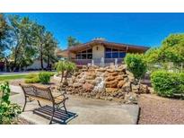 Charming home exterior with a unique rock waterfall feature and mature trees at 1550 N Stapley Dr # 95, Mesa, AZ 85203