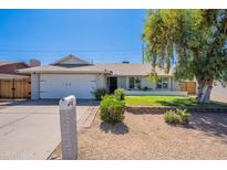 Charming single-story home featuring a well-maintained front yard with mature trees and a white mailbox at 17634 N 34Th Ln, Phoenix, AZ 85053