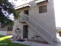 Two story condo building with private stairway, small table and chairs, and simple landscaping at 413 E Bruce Ave # D, Gilbert, AZ 85234