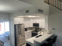 Bright kitchen featuring white cabinets, stainless steel appliances, and a convenient breakfast bar at 500 N Roosevelt Ave # 53, Chandler, AZ 85226